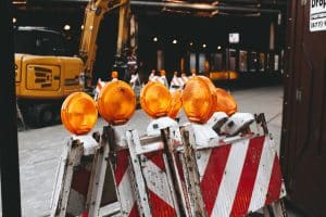 Zone en construction avec panneaux de signalisation et grue.