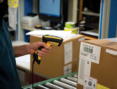 Un opérateur scannant un code barre sur un colis